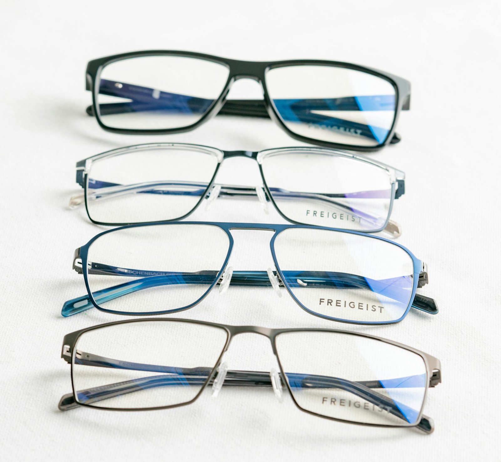 A close-up of modern Freigeist eyeglasses on a white surface.