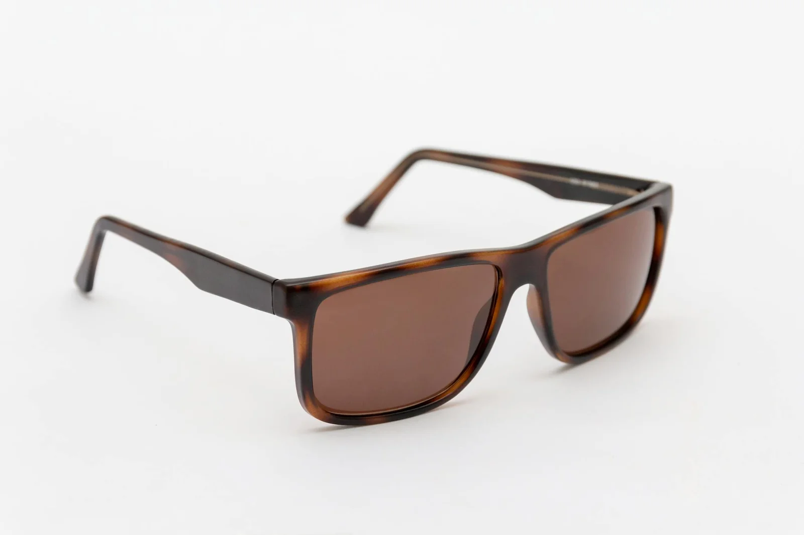 Stylish brown sunglasses close-up on a clean white backdrop, perfect for fashion themes.