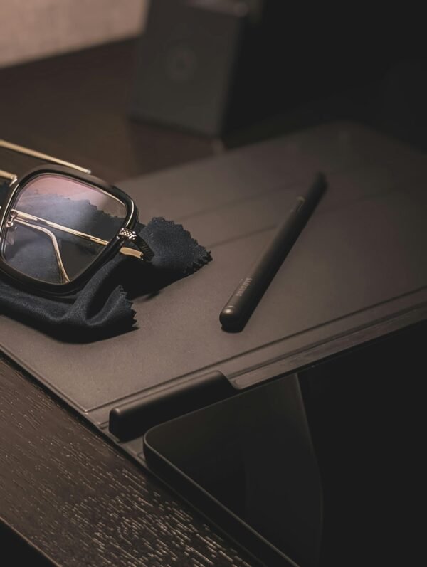 Stylish eyeglasses on a tablet with a stylus, creating a sophisticated and modern look.