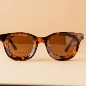 Stylish tortoiseshell sunglasses on a beige backdrop. Perfect for summer fashion.