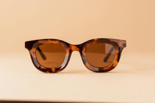 Stylish tortoiseshell sunglasses on a beige backdrop. Perfect for summer fashion.